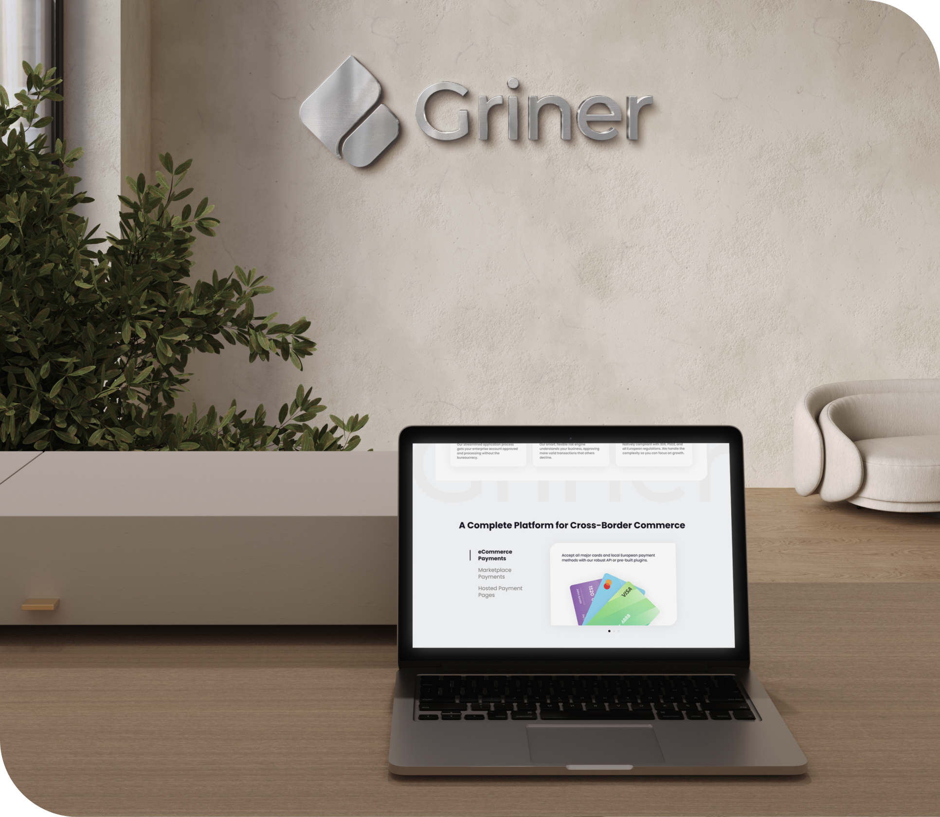 A laptop on a desk in front of a wall with the Griner logo